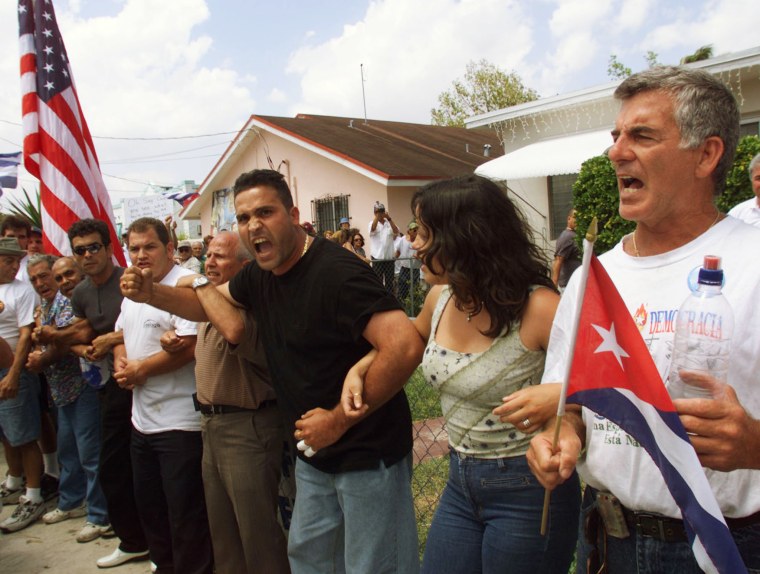 Image: PROTESTORS LINK ARMS IN FRONT OF ELIAN GONZALEZ FLORIDA HOME.